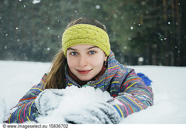 the girl lies in the snow and smiles