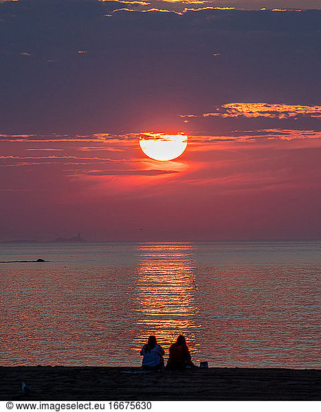 The golden sun rising beyond the ocean's horizon.
