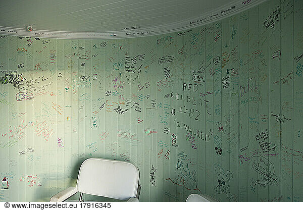 The graffiti on the walls of a lighthouse  an empty room with a chair  drawings and messages.