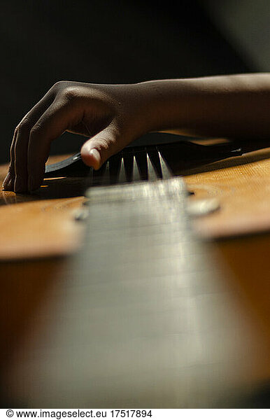 the hands of a teenager playing the guitar