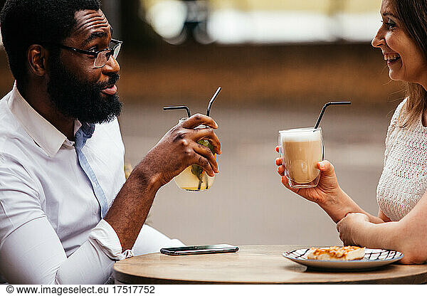 The happy couple are drinking and having fun in a street cafe