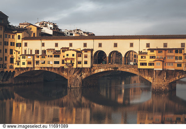 The historic medieval Ponte Vecchio over the Arno River in the historic city in Tuscany