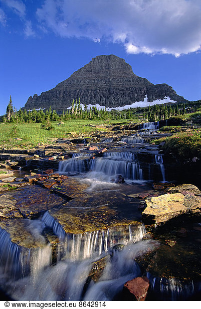 The landscape of Glacier National Park  to Mount Reynolds peak  and Logan Pass. Water flowing over rocks.