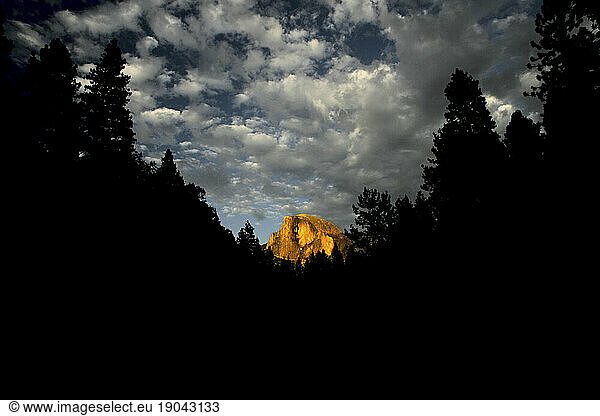 The last of the setting sun illuminates Half Dome monolith in Yosemite National Park  California  USA; Summer 2005.