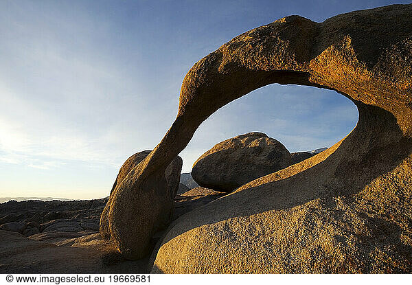 The Mobius Arch is illuminated at sunrise in the Alabama Hills near the town of Lone Pine  CA.
