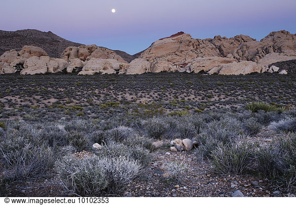 The moon rising over the mountains in Red Rock Canyon in Nevada.