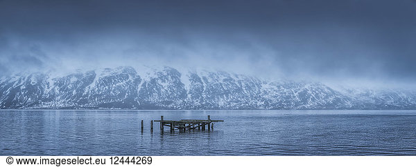 The old dock in Djupavik  Iceland in moody weather with clouds hanging low over the mountains  Djupavik  West Fjords  Iceland