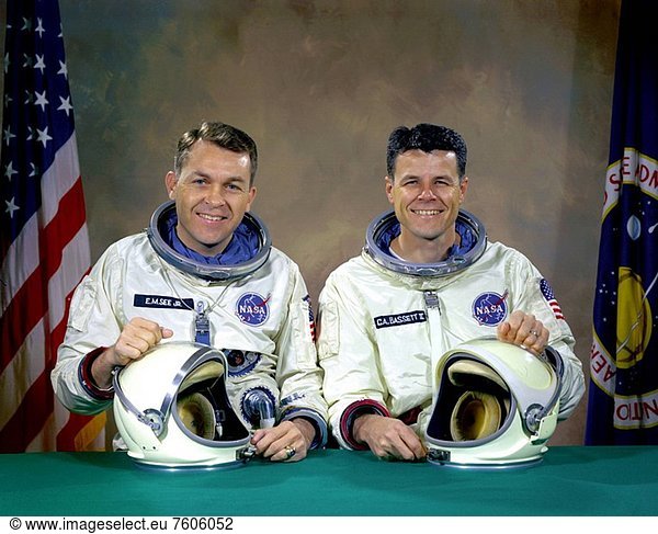 The original Gemini 9 prime crew  astronauts Elliot M. See Jr. left  command pilot  and Charles A. Bassett II  pilot  in space suits with their helmets on the table in front of them. On February 28  1966 the prime crew for the Gemini 9 mission were killed when their twin seat T_38 trainer jet aircraft crashed into a building in which the Gemini spacecraft were being manufactured. They were on final approach to Lambert_Saint Louis Municipal Airport when bad weather conditions hampered pilot See´s ability to make a good visual contact with the runway. Noticing the building at the last second as he came out of the low cloud cover  See went to full afterburner and attempted to nose_up the aircraft in an attempt to miss the building. He clipped it and his plane crashed.