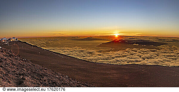 The panorama view from the summit of Haleakala at sunset in Haleakala National Park  Maui's dormant volcano  Hawaii. The observatories  collectively known as Science City are on the far left; Maui  Hawaii  United States of America