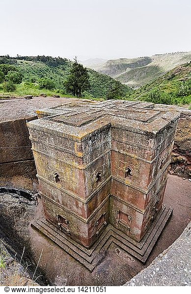 The rock-hewn churches of Lalibela in Ethiopia. Pilgrim praying in front of a church. The churches of Lalibela have been constructed in the 12th or 13th century. They have been hewn from the solid rock and are considered to be one of the largest monolithic structures ever build by mankind  Africa  East Africa  Ethiopia  Lalibela