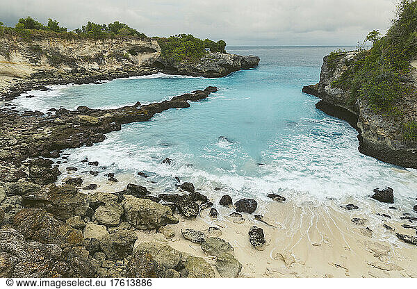 The rocky coast and beachfront of the resort town of Lembongan at the edge of the turquoise waters off the coast of Bali; Nusa Islands  Klungkung Regency  Indonesia