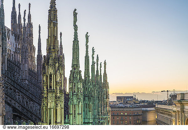 The stretched statue pillars on the top of the Cathedral in Milan before the sunset