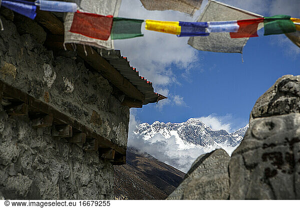 The summit of Mount Everest seen past prayer flags in Tengboche  Nepal