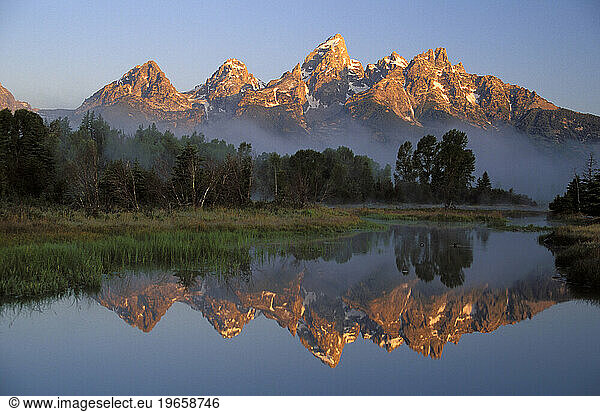 The Teton Range with the Grand Teton in the center reflected in the Snake River  Grand Teton National Park  Wyoming.