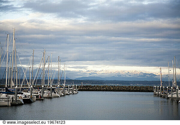 The view of a marina with snow capped mountains in the distance.
