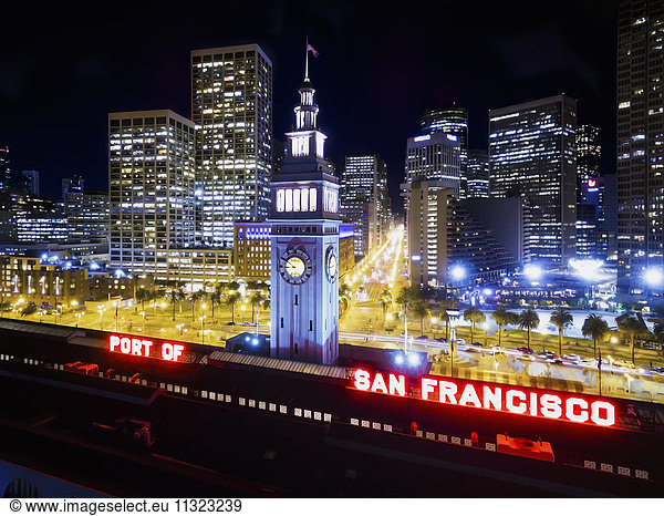 The view over the Ferry building  the clock tower and sign saying The Port of San Francisco at night.