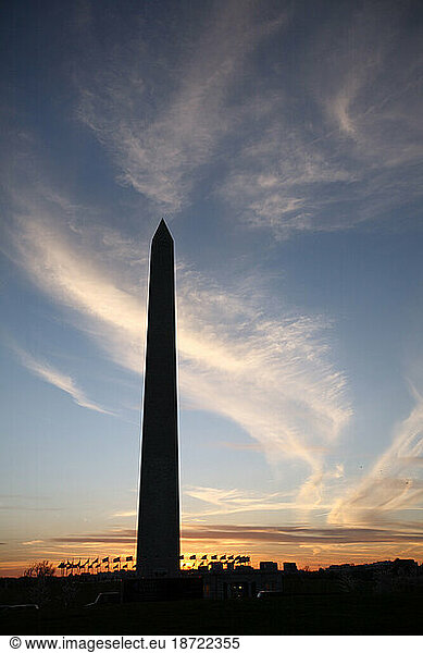 The Washington Monument is silhouetted at sunset on the Mall in Washington DC in spring.