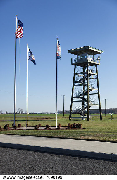 The watch tower of a Correctional Facility. Prison entrance  with flagpoles.