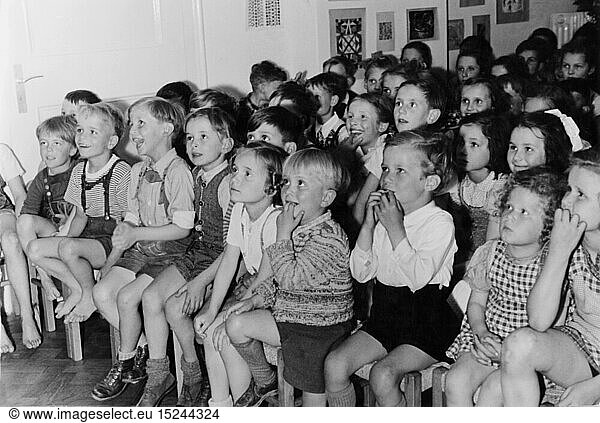 theatre / theater  audience  group of children following a performance of a Punch and Judy show  1950s