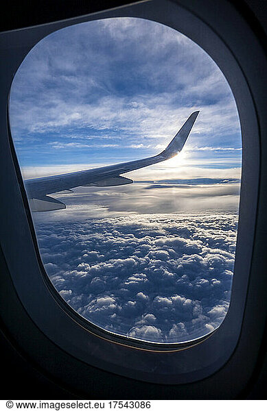 Thick clouds seen through window of airplane flying above