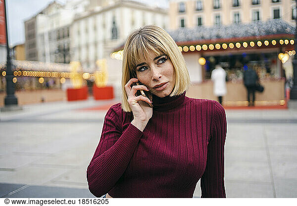 Thoughtful blond woman talking on smart phone