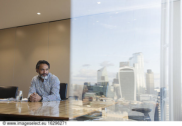 Thoughtful businessman in highrise conference room  London  UK