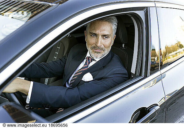 Thoughtful businessman wearing suit sitting in car