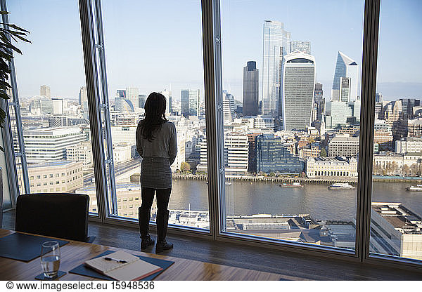 Thoughtful businesswoman looking at cityscape view  London  UK