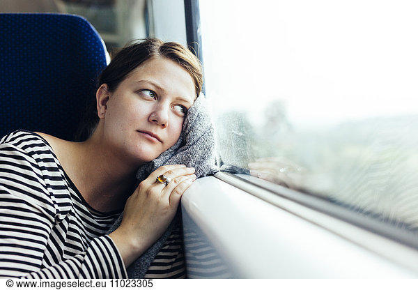 Thoughtful businesswoman looking out through train window