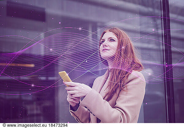 Thoughtful businesswoman with smart phone in front of building
