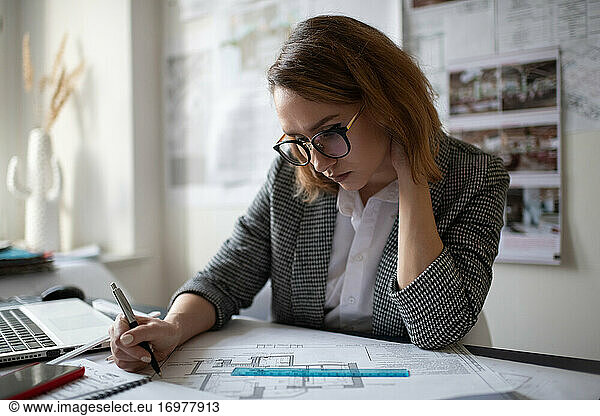 Thoughtful female architect examining draft