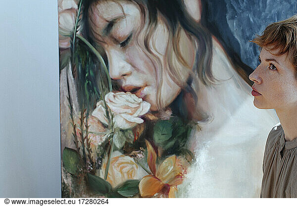 Thoughtful female artist by canvas painting in art studio