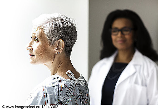 Thoughtful female patient with doctor in background