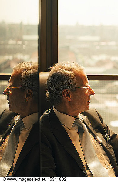 Thoughtful lawyer sitting by window at law office