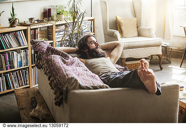 Thoughtful man relaxing on sofa at home