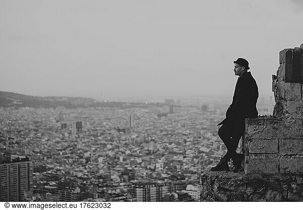 Thoughtful man standing on rock in city