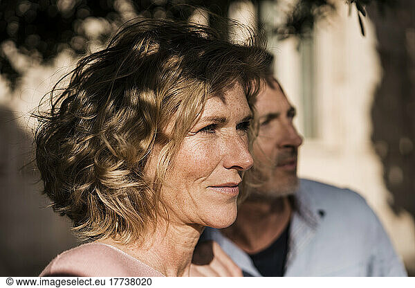 Thoughtful mature woman by man on sunny day
