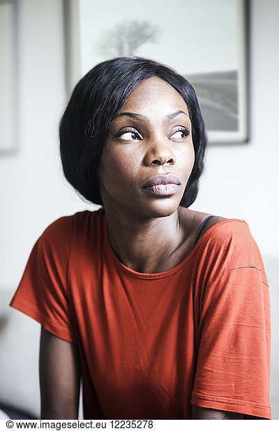 Thoughtful mid adult woman looking away at home