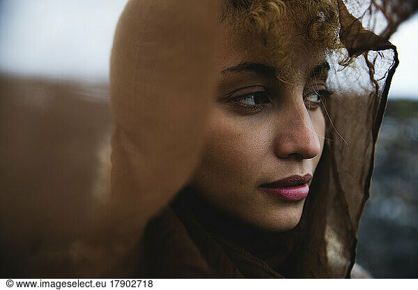Thoughtful woman head covered with scarf