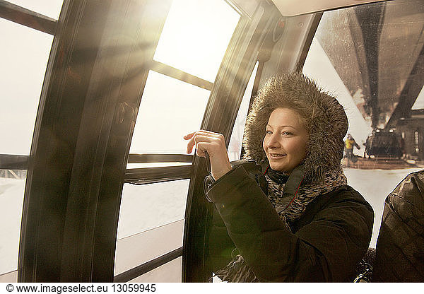 Thoughtful woman looking through cable car window
