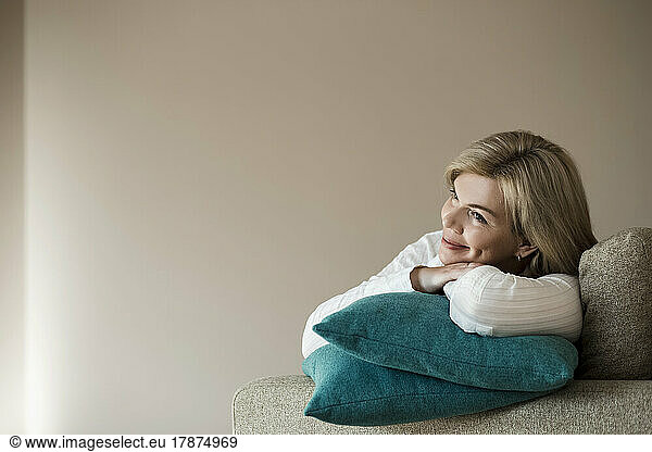 Thoughtful woman relaxing on couch at home