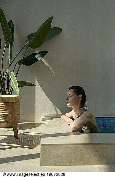 Thoughtful woman resting in hot tub at spa