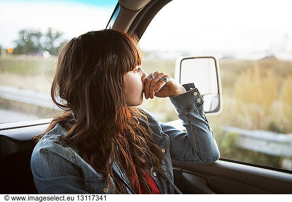 Thoughtful woman travelling in camper van looking out window