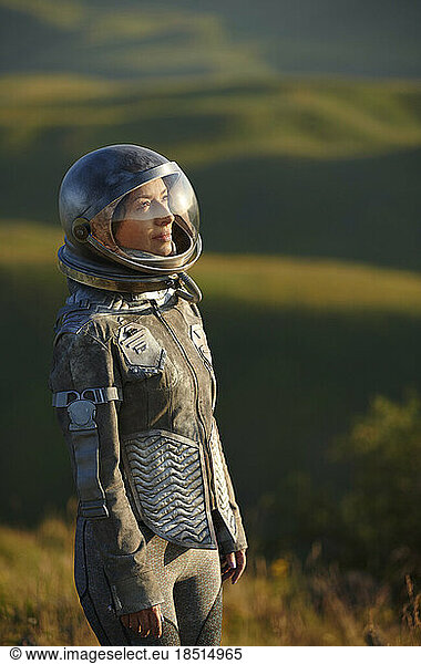 Thoughtful woman wearing space costume and helmet