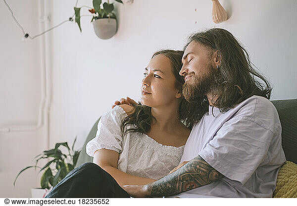 Thoughtful woman with hipster man in bedroom at home
