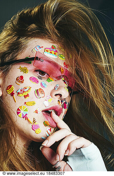 Thoughtful woman with stickers on face