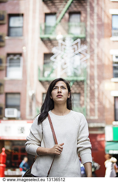 Thoughtful young woman walking in city