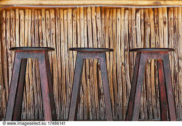 Three bar stools and bar on a beach
