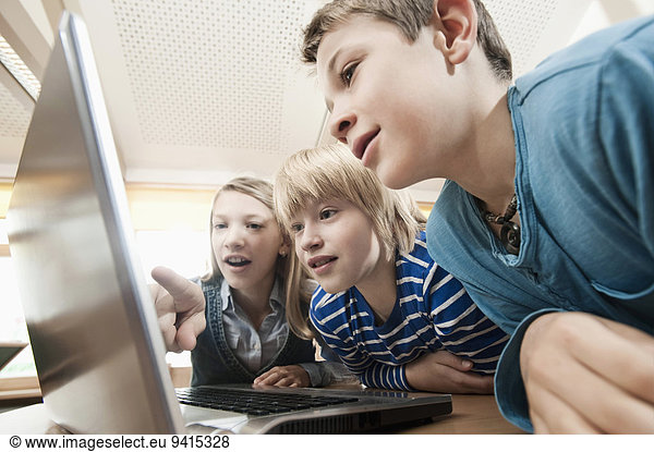 Three children looking at laptop