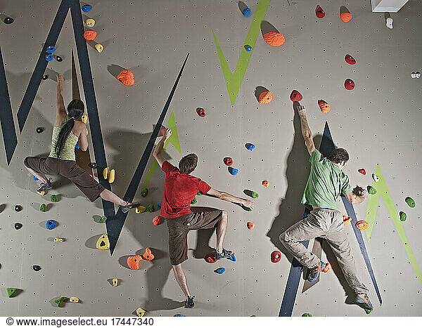 three climbers bouldering at indoor climbing wall in London
